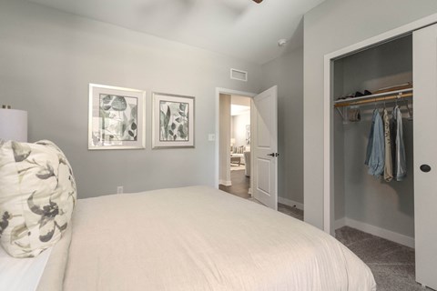 a bedroom with a large white bed and a closet